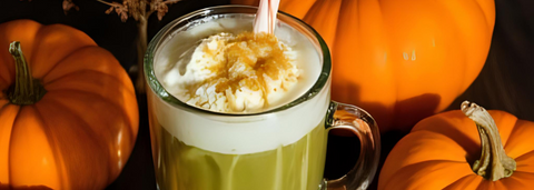 Green smoothie surrounded by pumpkin