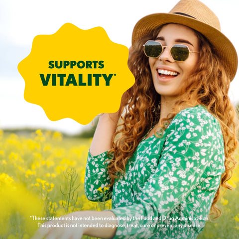 Woman in a green dress and straw hat standing in a field of yellow flowers with a 'Supports Vitality' label.
