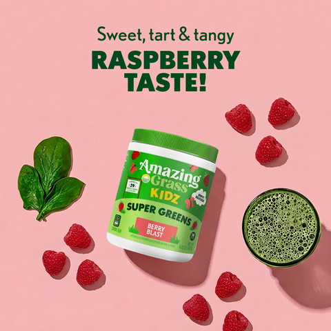 Container of Amazing Grass Kidz Super Greens with raspberries and a green smoothie on a pink background